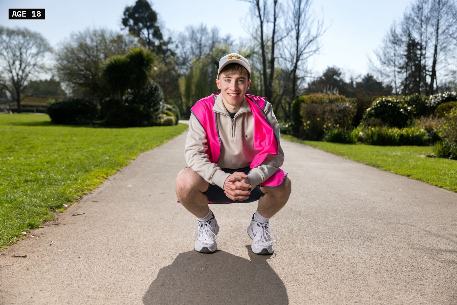 Ben, aged 18, crouching outdoors in a park